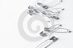 Many safety pins on white background, space for text