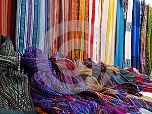 Many scarfs put next to eachother in all colores at an andean market of South America