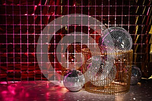 Many shiny disco balls on floor near foil party curtain. Space for text