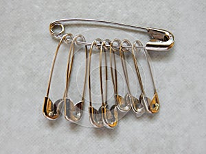 many size of safety pin on gray background