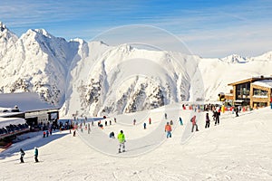 Many skiers and snowboarders riding over Idalp downhill plato at austrian alipine Ischgl resort on briht sunny day at