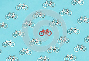 Many small bicycles, one red is standing out, leadership concept, think different, minimalistic lifestyle, alternative transportat