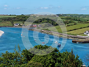Many small boats are anchored in Clonakilty Bay on a sunny spring day. Seascape of the south of Ireland. Blue sea water