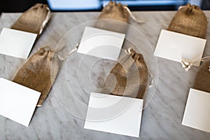 Many small brown bags of fabric and white cards