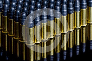 Many small caliber bullets lined up with reflection