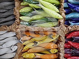 Many small ceramic fishes, pretty travel souvenirs as decoration objects.