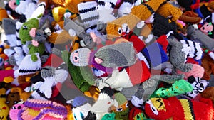 Many small, colorful, knitted finger puppets.  Self-made for sale at a flea market. Close-up