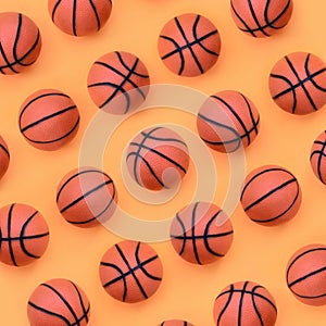 Many small orange balls for basketball sport game lies on texture background of fashion pastel orange color paper in minimal