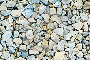 Many small stones of different colors, gravel or crushed stone close-up texture