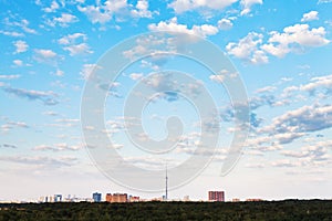 Many small white clouds in blue sky over city