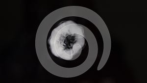 Many smoke vape vortex rings moving towards screen in a dark background isolated