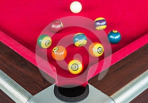 Many snooker balls or pool balls near the corner hole on red table