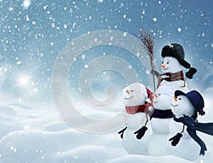 Many snowmen standing in winter Christmas landscape