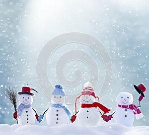 Many snowmen standing in winter Christmas landscape photo