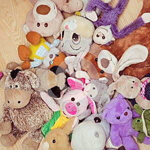 Many soft plush toys lie on floor in the children`s room