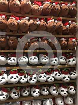 Many soft toys - pandas and polar bears on shop shelvesMany soft toys - pandas and bears wearing Santa`s hat on shop shelves