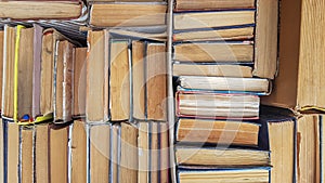 Many sorted old books are stacked as a background front view. Stack of used old books in the school library. Old and