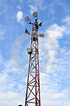 Many speakers on red tower with blue sky day