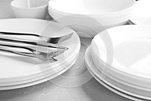 Many stacked plates with cutlery