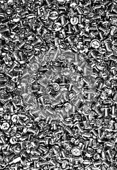 Many steel computer screws. The background of the fastener