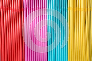 Many straws of red, blue, yellow and pink for drinks and cocktails at parties