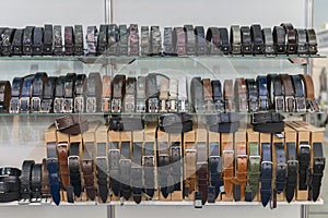 Many styles and colors of female leather belt in its store's shelves ready for sale. Leather belts on the shelf in the store