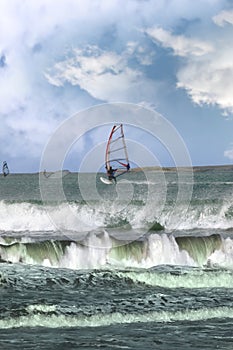 Many surfers windsurfing in a storm