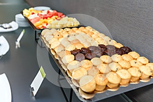 Many Sweet muffins and sliced fruits on table on a coffee break in the office