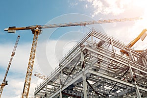 Many tall cranes on a construction site. Developing modern residential and commercial property. Growth concept. Metal frame of a