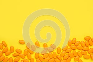 Many tasty dragee candies on yellow background, flat lay. Space for text
