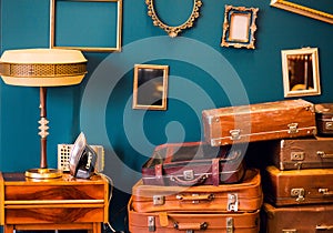 Many things - suitcases, a lamp, an iron, photo frames - in one room