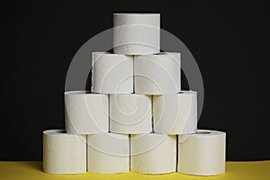 Many toilet paper rolls. Soft hygienic paper. Black yellow background