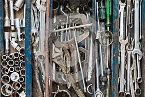 Many tools in rustic compartments toolbox. Technical machanic to