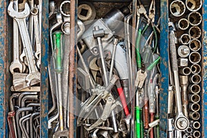 Many tools in rustic compartments toolbox. Technical machanic to