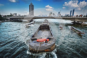 Many transport boats and passenger ships that are important in transportation are traveling through the city center of Bangkok in