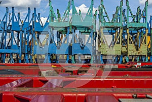 Many transports for reels stacked behind truck trailers with sun