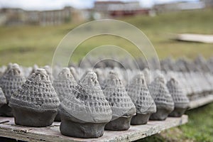 Many `Tsa-tsa` cones being baked in the sun. A traditional clay lucy charms, in shape of `Chorten` a Buddhist monument