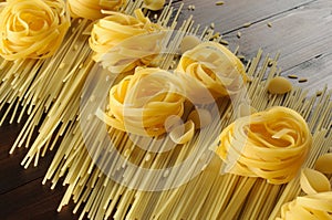 Many types of pasta: Conchiglie, Spaghetti, Fettuccine, orzo. wood background. Close up