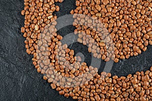 Many of uncooked brown kidney beans on a dark background