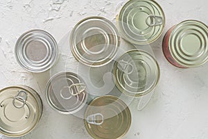 many unopened tin cans with meals such as meat and fish on the table, conserved foods