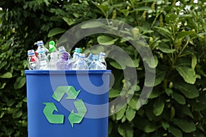 Many used bottles in trash bin, space for text. Plastic recycling