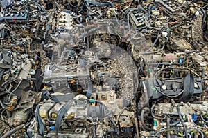 many used internal combustion engines on the ground of junkyard at cloudy day