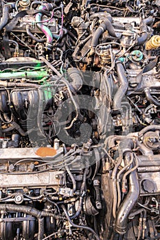 many used internal combustion engines on the ground of junkyard at cloudy day