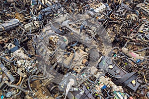 many used internal combustion engines on the ground of junkyard at cloudy day