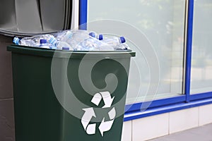 Many used plastic bottles in trash bin outdoors. Recycling problem