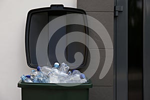 Many used plastic bottles in trash bin outdoors. Recycling problem