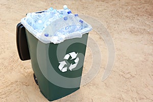 Many used plastic bottles in trash bin outdoors, space for text. Recycling problem