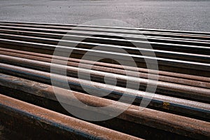 Many used rusty rails of different length stored at a ground for old rails replacement. Diagonal placement photo