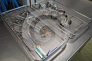 Many various cleaned and disinfected surgical instruments lie unsorted in metal sieves