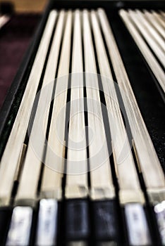 Many violin bows are laying in a row on the desk